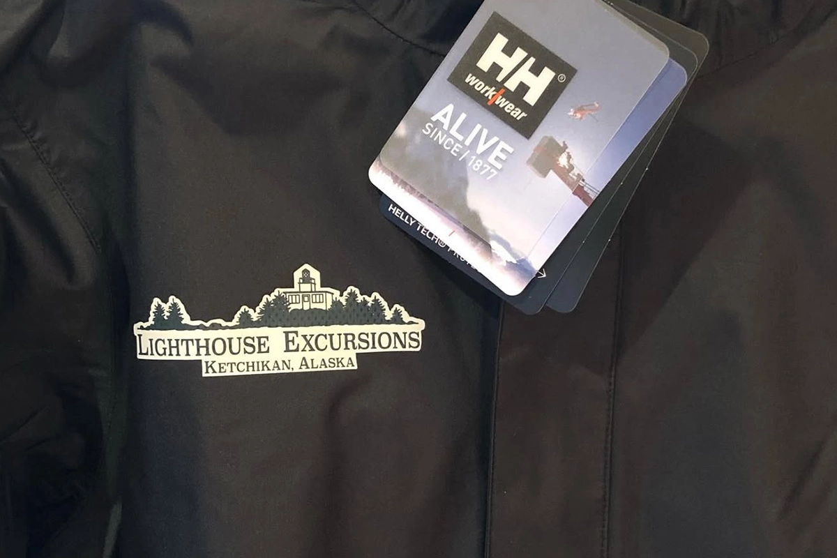 Black Helly Hansen workwear jacket embroidered with the Lighthouse Excursions logo and “Ketchikan, Alaska.”