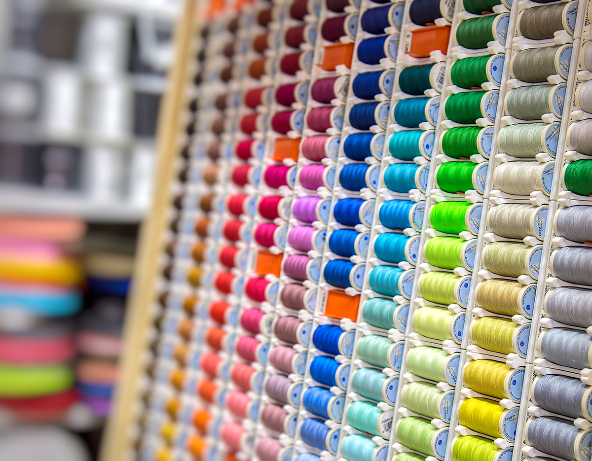 Wall display of embroidery thread samples in multiple colors, representing extensive customization options.