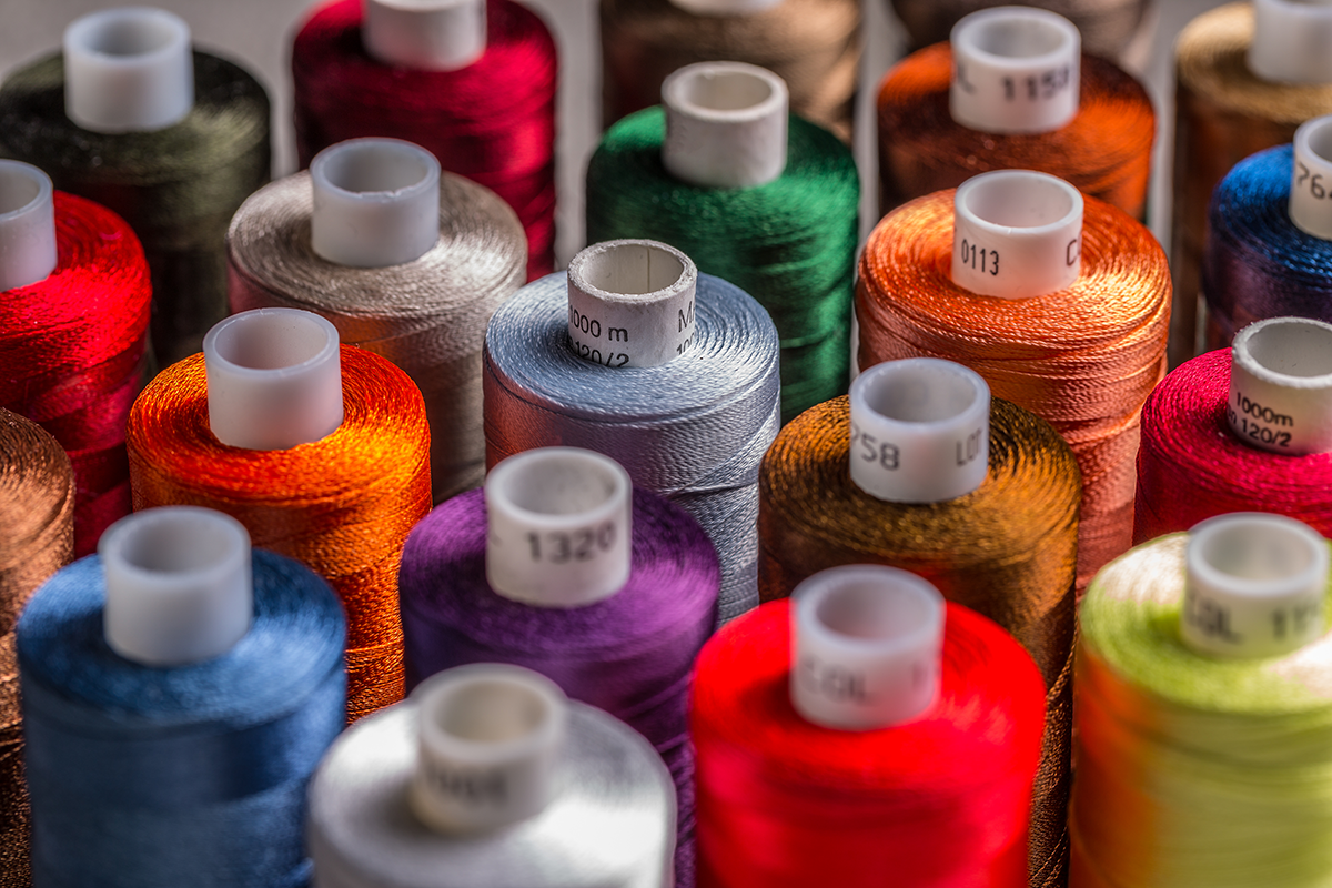 Colorful spools of embroidery thread arranged together, representing a wide selection of thread colors for custom designs.