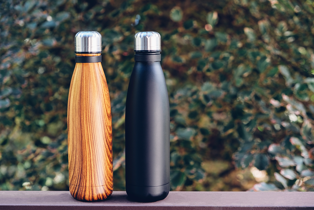 Two reusable insulated water bottles displayed outdoors, representing customizable branded drinkware options.