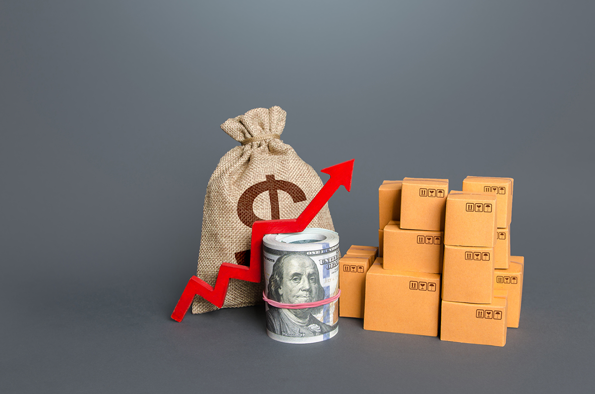 Shipping cost increase concept with dollar bag, rising red arrow, stacked boxes, and rolled US currency